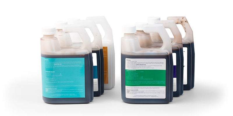 Several bottles of brown liquid with different labels: lawn micronutrients and fertilizers.