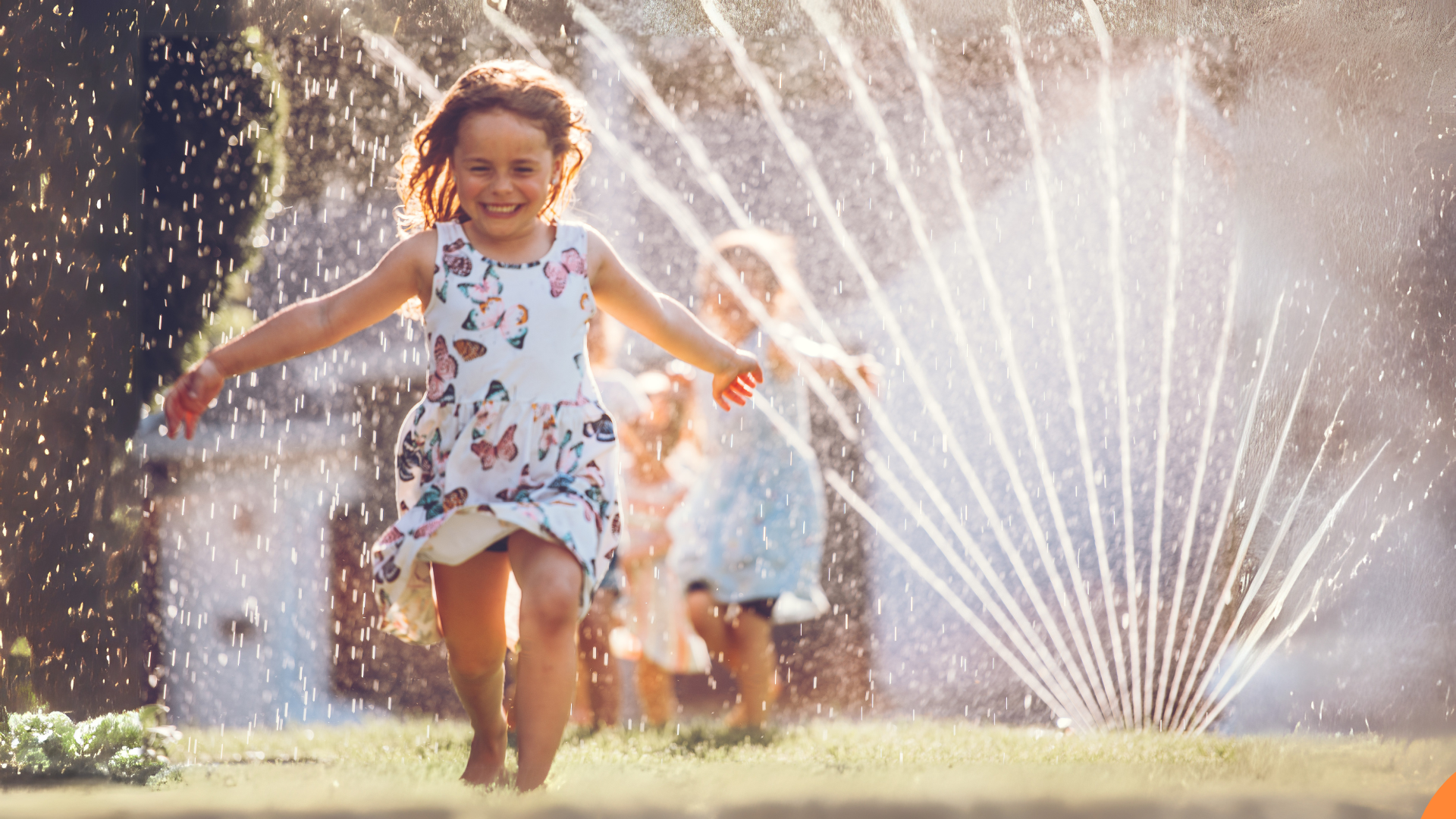 Children playing with a sprinkler in a garden