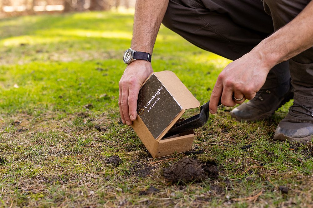 Lawnbright soil test kit being used to collect a lawn soil sample.